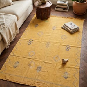 Yellow sabra rug with embroidered geometric motifs and a zigzag border in a living room