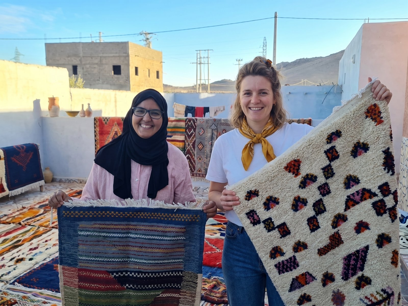 Handwoven Taznakht rug held up on a rooftop in southern Morocco