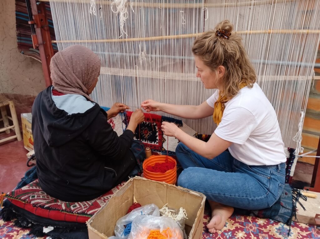 Weaver working at a vertical loom on a Moroccan rug
